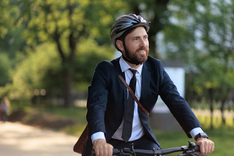 Mann mit Helm auf seinem Betriebsfahrrad fährt zur Arbeit