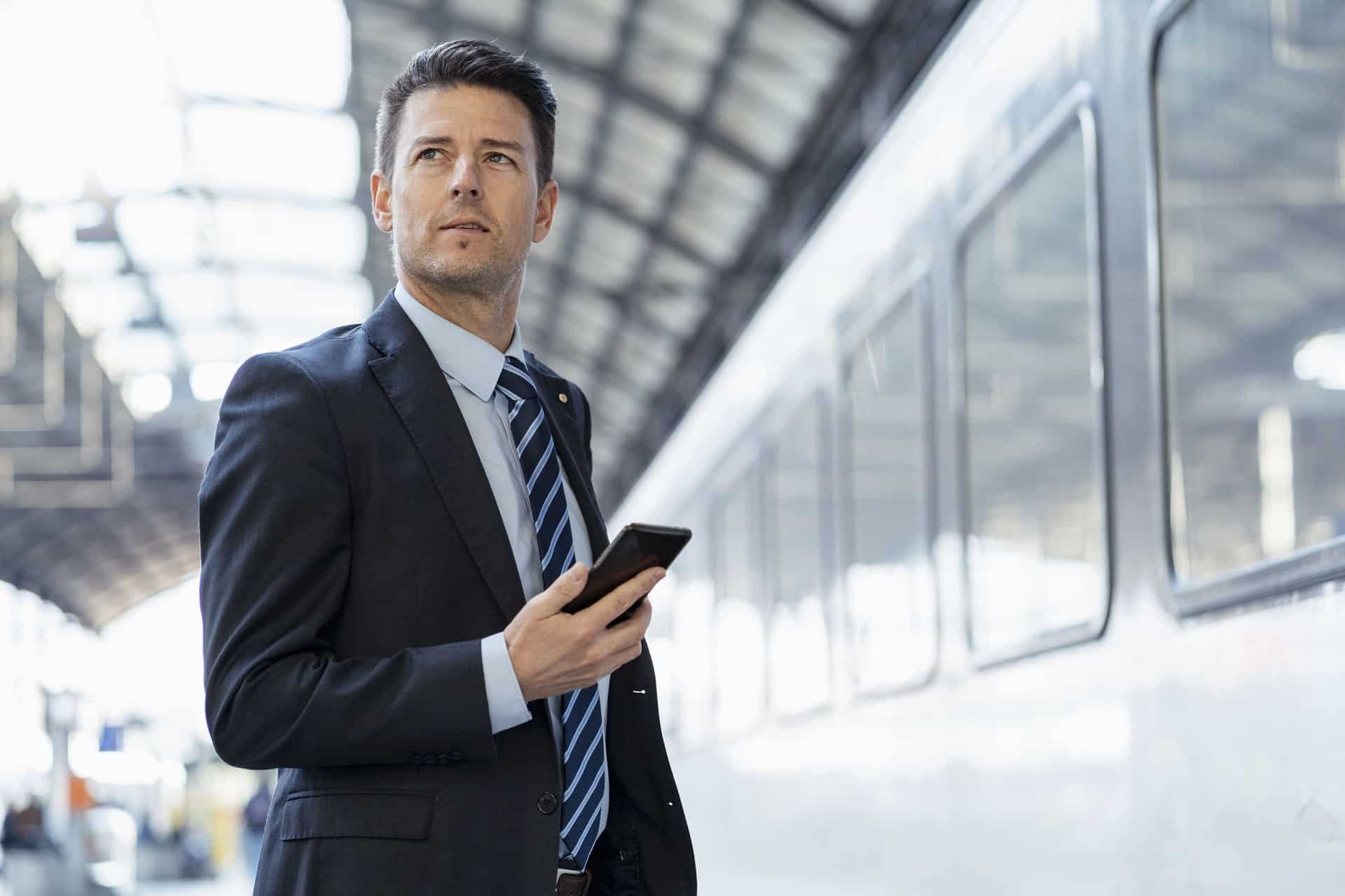 businessman with cell phone on station platform 2023 11 27 05 11 47 utc 3 1