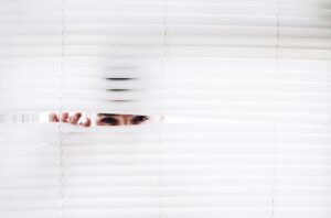 Chef überwacht Mitarbeiter heimlich durch die Schlitze der Jalousie