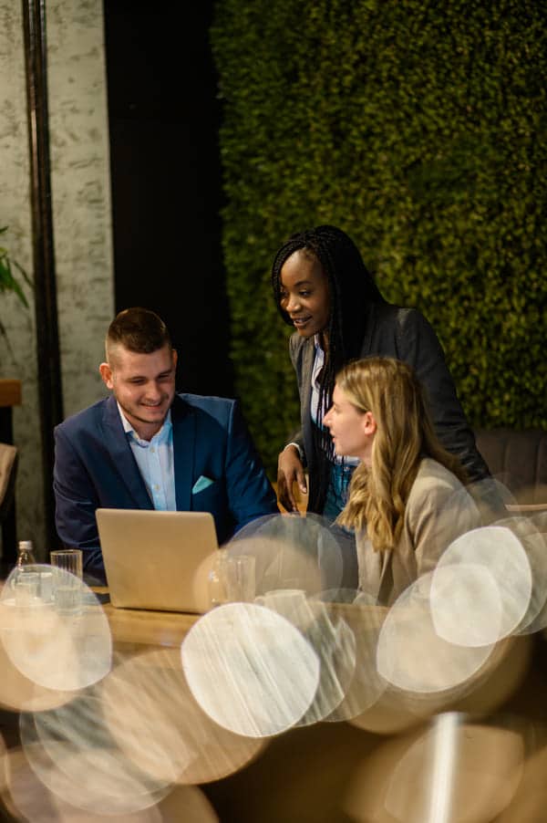 cheerful work colleagues working on a laptop