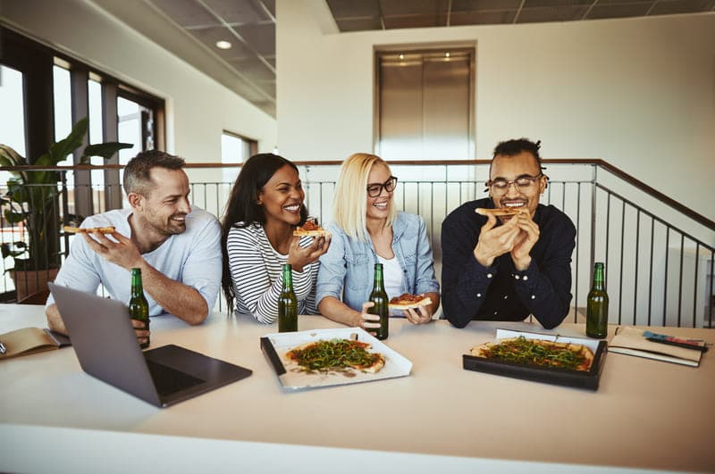 Eine Gruppe von Mitarbeitern essen im Büro