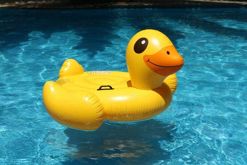 Große aufblasbare gelbe Ente im Pool im Urlaub