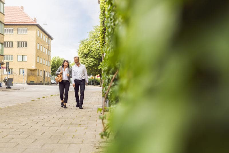 senior man and woman walking on city street