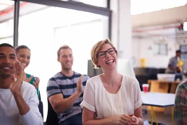 Glückliche Mitarbeiter im Büro lachen