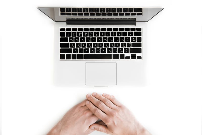 top view of human hands and laptop computer