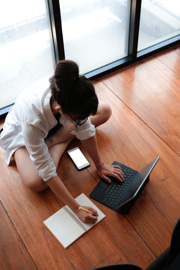 woman using computer tablet and making note